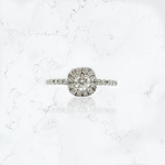 Anillo de compromiso en platino, modelo solitario halo, con diamante corte brillante central de 0,29 cts, rodeado de 12 brillantes de 0,010 cts cada uno, y con 10 brillantes de 0,015 cts cada uno en el cuerpo. 