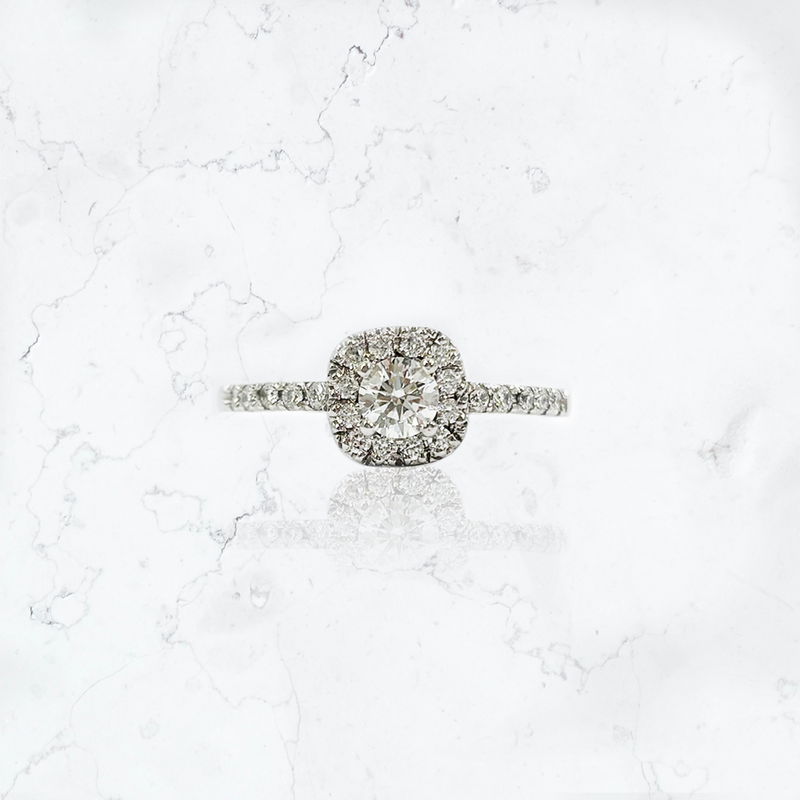 Anillo de compromiso en platino, modelo solitario halo, con diamante corte brillante central de 0,29 cts, rodeado de 12 brillantes de 0,010 cts cada uno, y con 10 brillantes de 0,015 cts cada uno en el cuerpo. 